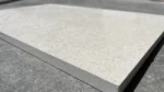 Close-up of a Marva Limestone tile corner showing thickness and speckled texture