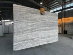 Marjan Silver Travertine slab with wavy horizontal veins and visible natural pores.